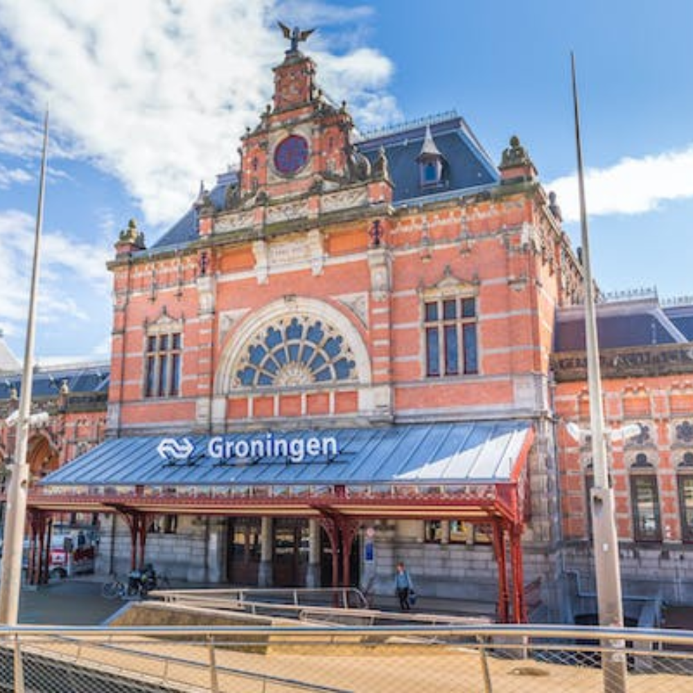 "Foto van het prachtige Groningen Centraal Station, een belangrijk transportknooppunt in de stad Groningen. Het gebouw is opvallend door zijn statige architectuur en biedt treinverbindingen naar verschillende steden binnen Nederland.
